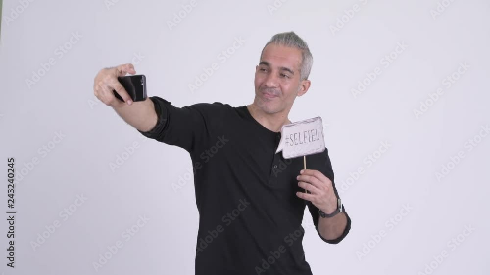 Happy handsome Persian man taking selfie with paper sign Happy handsome Persian man taking selfie with paper sign