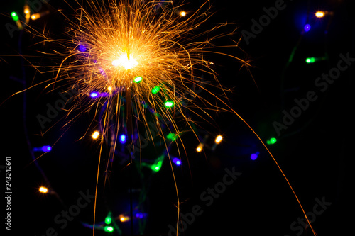 festive background with sparkler and new year lights closeup