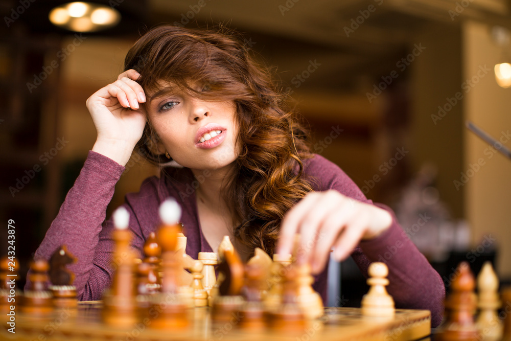 Woman playing chess indoor and thinking position, find winning move, strategy.