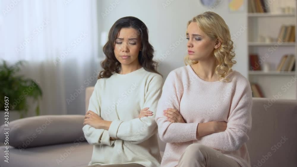 Young woman hugging and reconciling with female friend after quarrel, indoors Young woman hugging and reconciling with female friend after quarrel, indoors