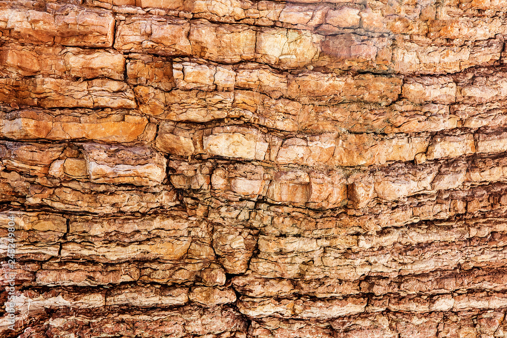 The surface of the rock with horizontal lines with a crack. Stone background