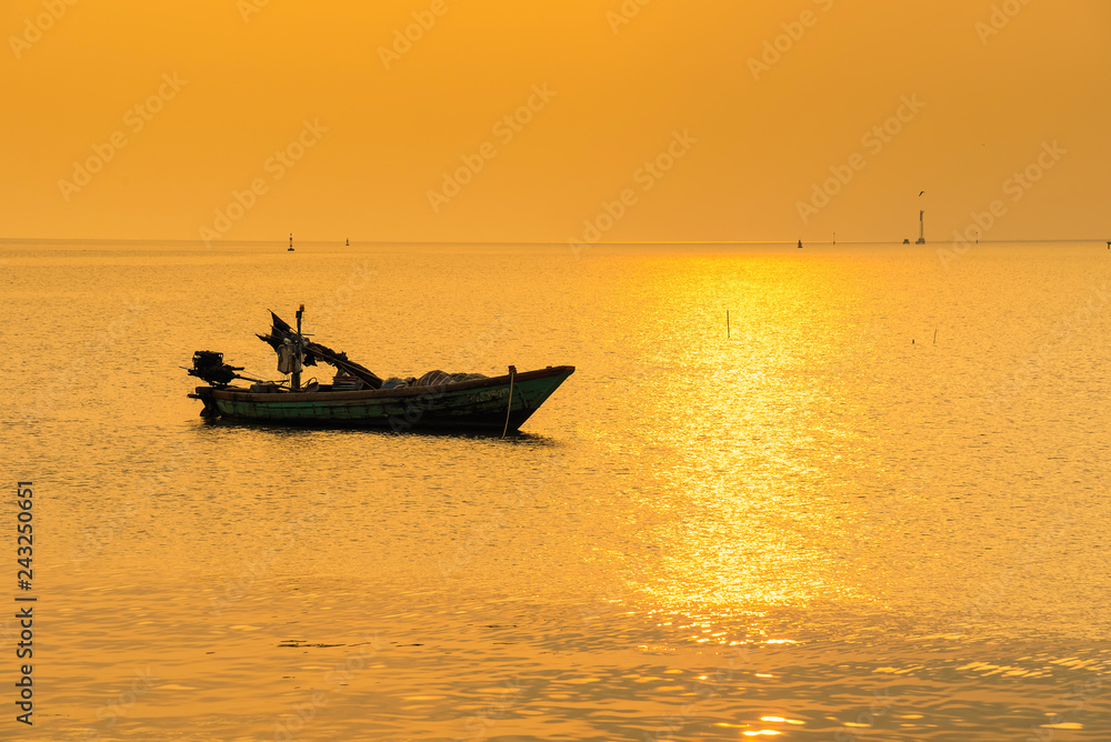 Beautiful sunrise on the beach and silhouette of fishing boat.Thailand.