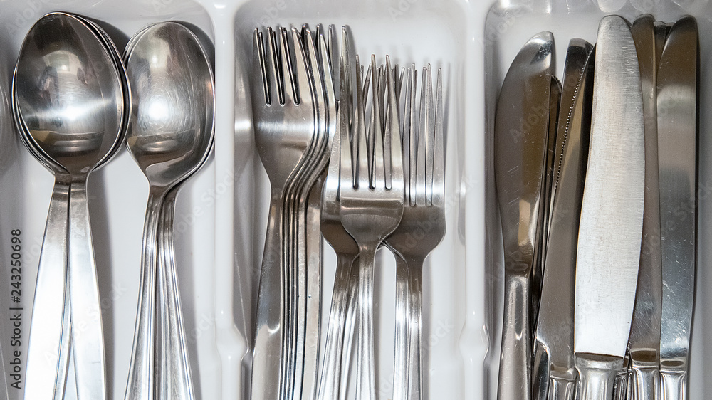 Steel silverware spoon, fork and knife piled in a drawer. Steel silverware spoon, fork and knife piled in a drawer.