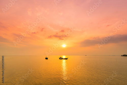 Beautiful sunrise on the beach and silhouette of fishing boat.Thailand. © bubbers