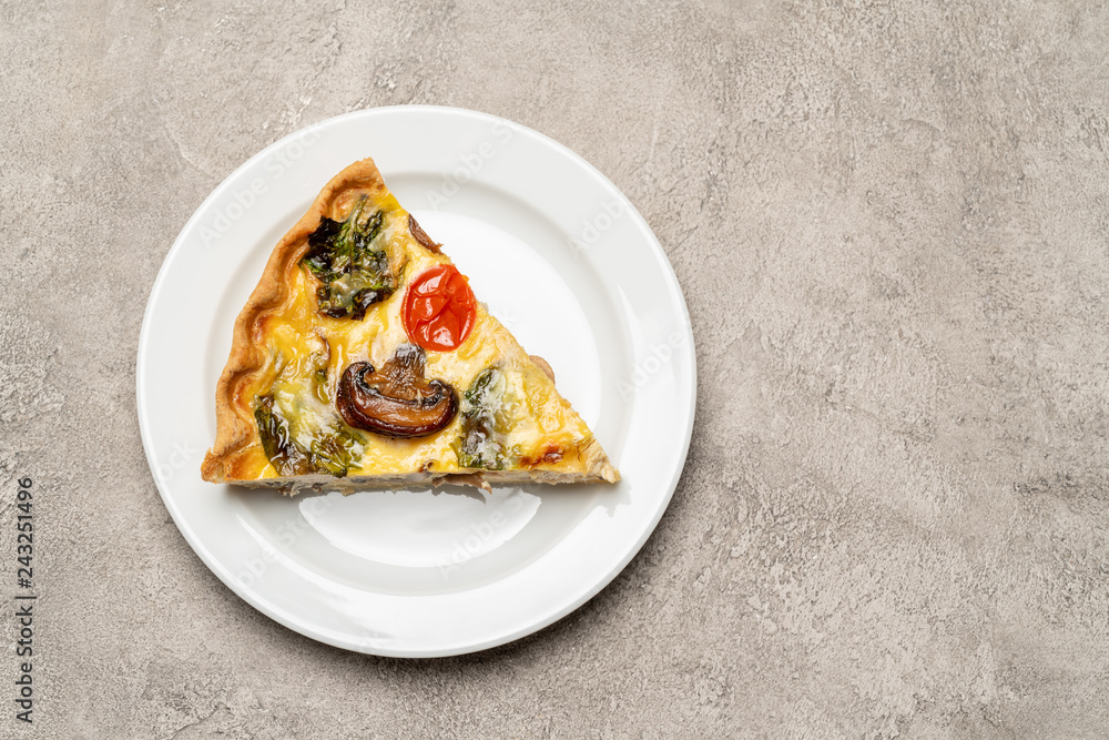 Slice of traditonal homemade spinach chicken quiche tart or pie on plate Slice of traditonal homemade spinach chicken quiche tart or pie on plate