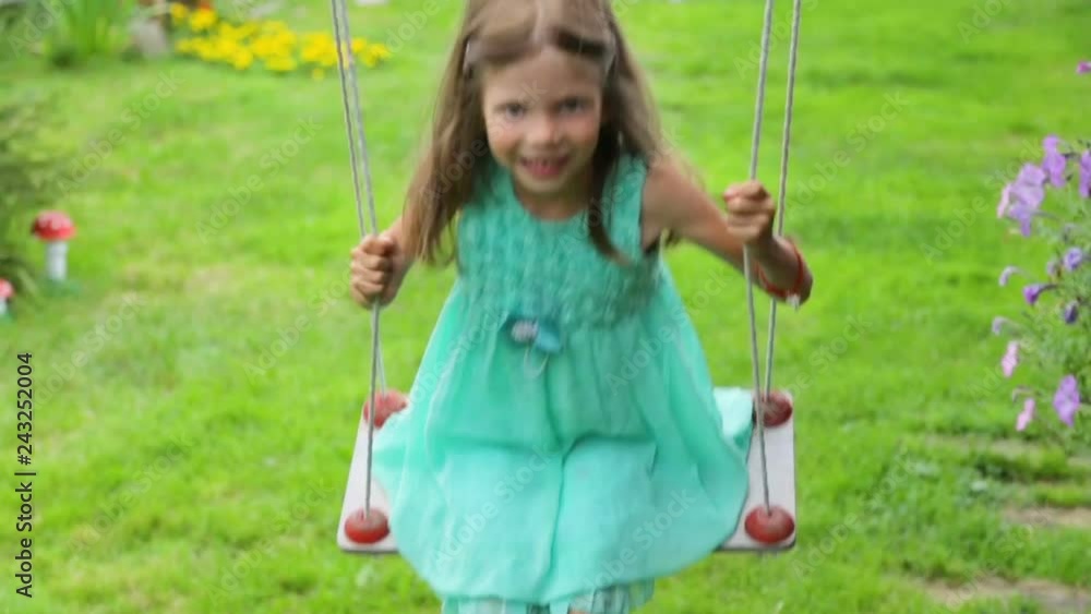 Little girl swinging in garden Little girl swinging in garden