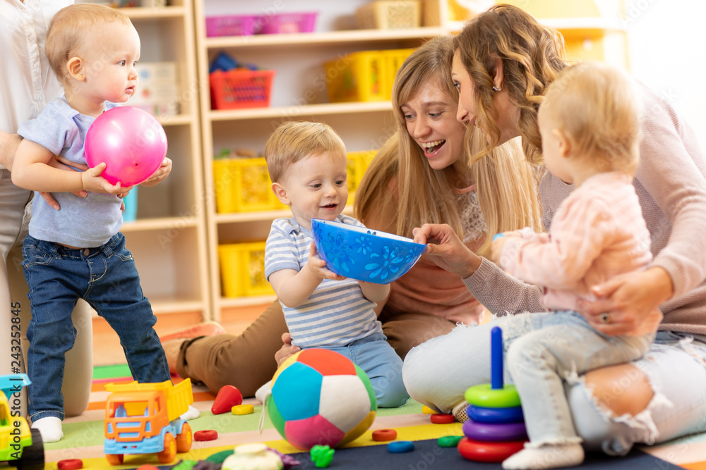 Fototapeta premium Group of happy moms with their babies in nursery