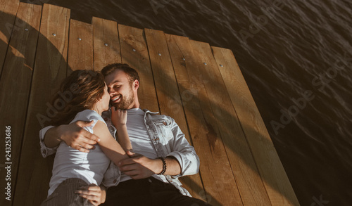 Cuddling young couple lying on pier © kegfire