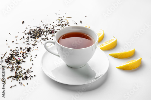 Cup of hot tea and lemon on white background
