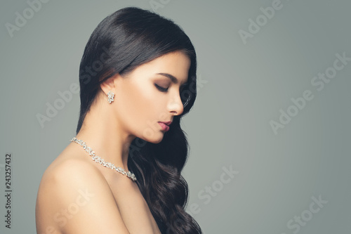 Glamorous woman with makeup, long hair curly hair, diamond necklace and earrings. Fashion jewelry portrait
