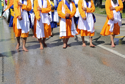 Sikh soldiers walk barefoot on the road during a religious rally photo