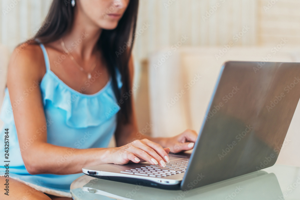 Fototapeta premium Portrait of young female freelancer working on laptop sitting in cafe
