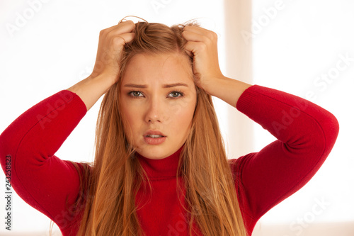 Young blonde woman having serious migrene suffering from horrible head ache feeling horrible pain.