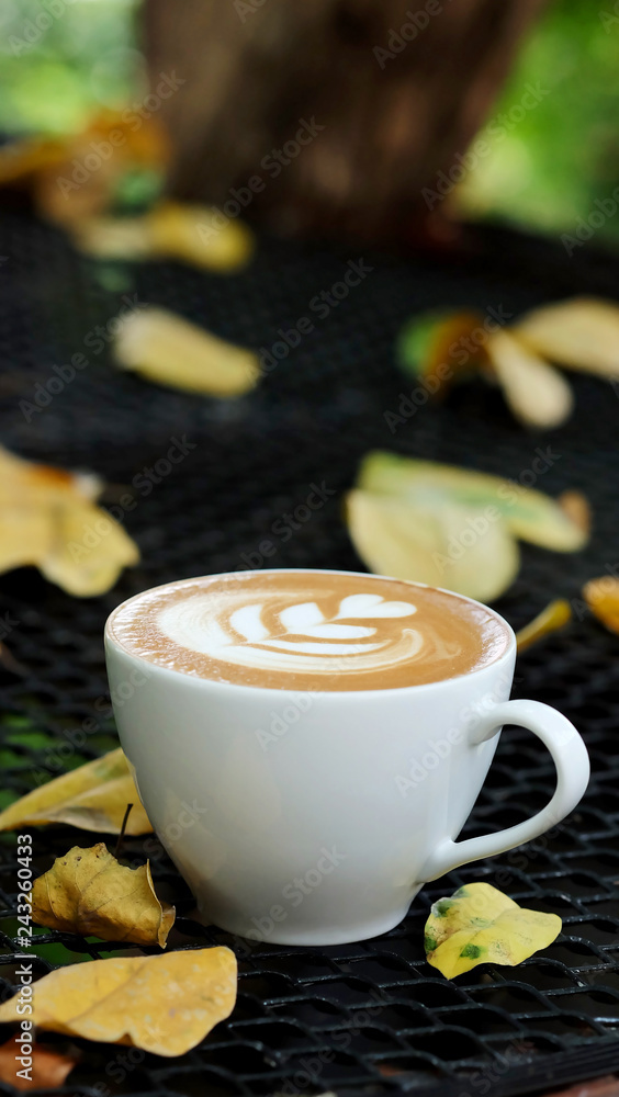 Special recipe hot latte on wood table with falling leaves and space for write wording served in a restaurant, value added design, coffee business is big and fast growing Special recipe hot latte on wood table with falling leaves and space for write wording served in a restaurant, value added design, coffee business is big and fast growing