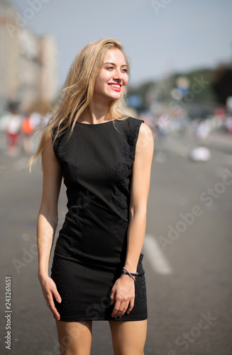 Delightful blonde model with long hair wearing fashionable black dress