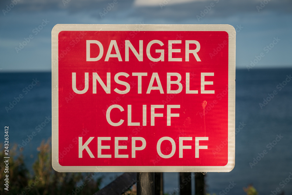 Sign: Danger unstable cliff, keep off, seen in Whitley Bay, Tyne And Wear, England, UK Sign: Danger unstable cliff, keep off, seen in Whitley Bay, Tyne And Wear, England, UK
