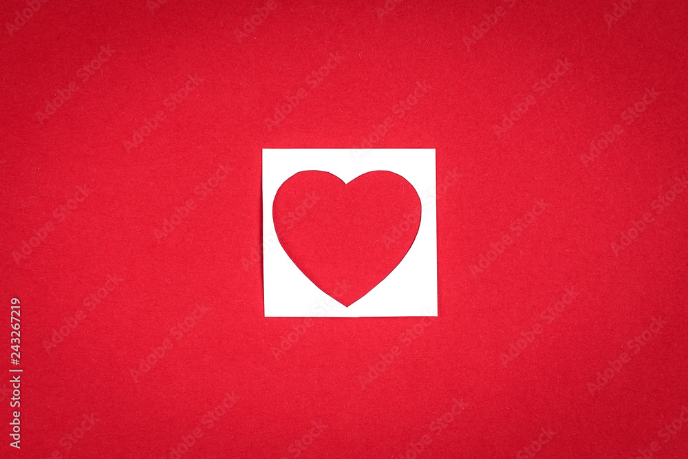 Small paper red heart inside the white square on red background. Valentine's day concept. Small paper red heart inside the white square on red background. Valentine's day concept.