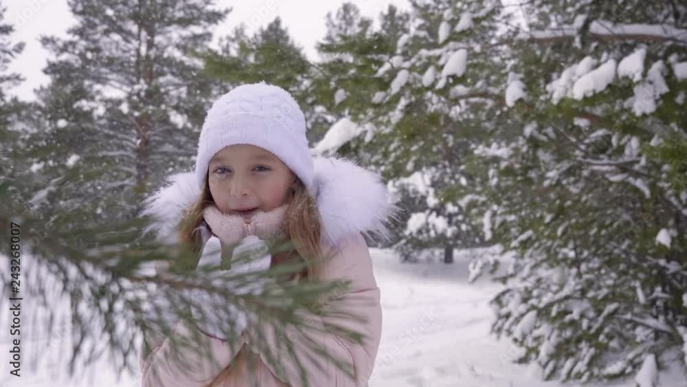 Little girl freezing in frosty woods. Front view cute girl trying get warm in winter forest. Cold teenage girl in frosty woods blowing on her hands while standing under snowfall. Cold up. Slow Motion Little girl freezing in frosty woods. Front view cute girl trying get warm in winter forest. Cold teenage girl in frosty woods blowing on her hands while standing under snowfall. Cold up. Slow Motion