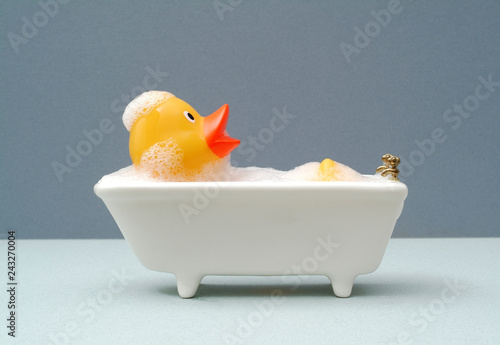 Obraz na plátně rubber duck taking a bath. grey baackground
