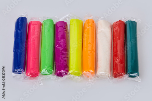 Set of colorful plasticine isolated on a white background. Plasticine play dough modeling clay in transparent package