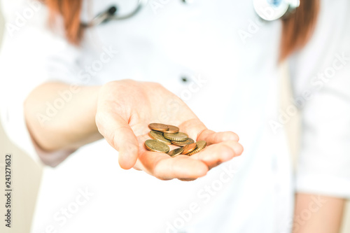 Obraz na plátne doctor holds coins in his hand, a symbol of poverty and destitution