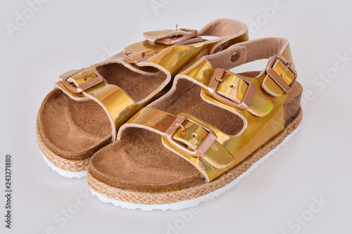 Kids golden sandals isolated on white background