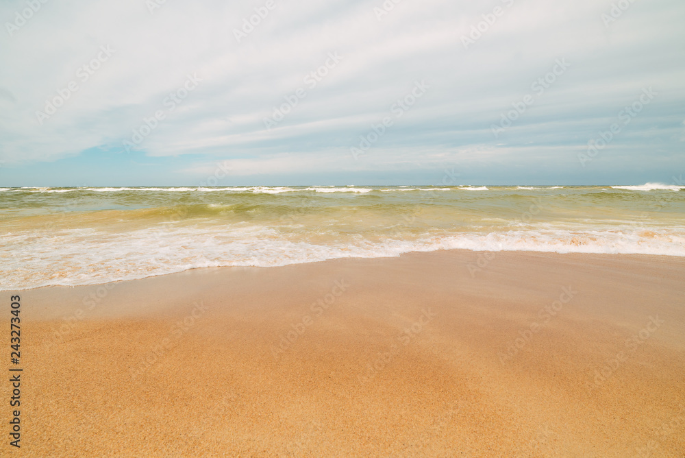 Endless beach scene, calm summer landscape of nature. Blue sky and soft ocean waves. White sand on the seashore