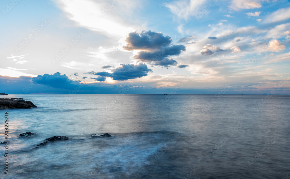 Long Exposure of the Mediterranean Sea Coast with Blue Sky in Southern Italy Long Exposure of the Mediterranean Sea Coast with Blue Sky in Southern Italy