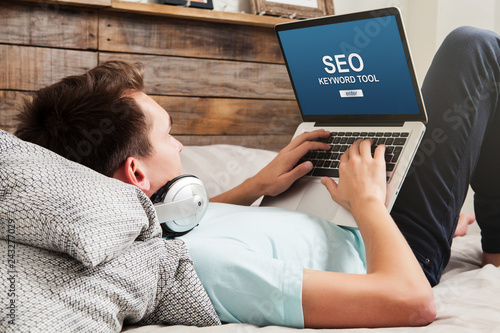 Man doing SEO keyword positioning with a laptop at home.