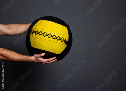 isolated med ball in hand on gray background photo