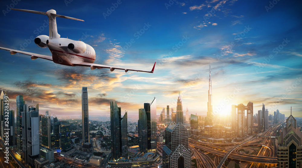 Naklejka premium Private jet plane flying above Dubai city