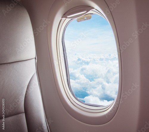 Airplane interior with window view of clouds.