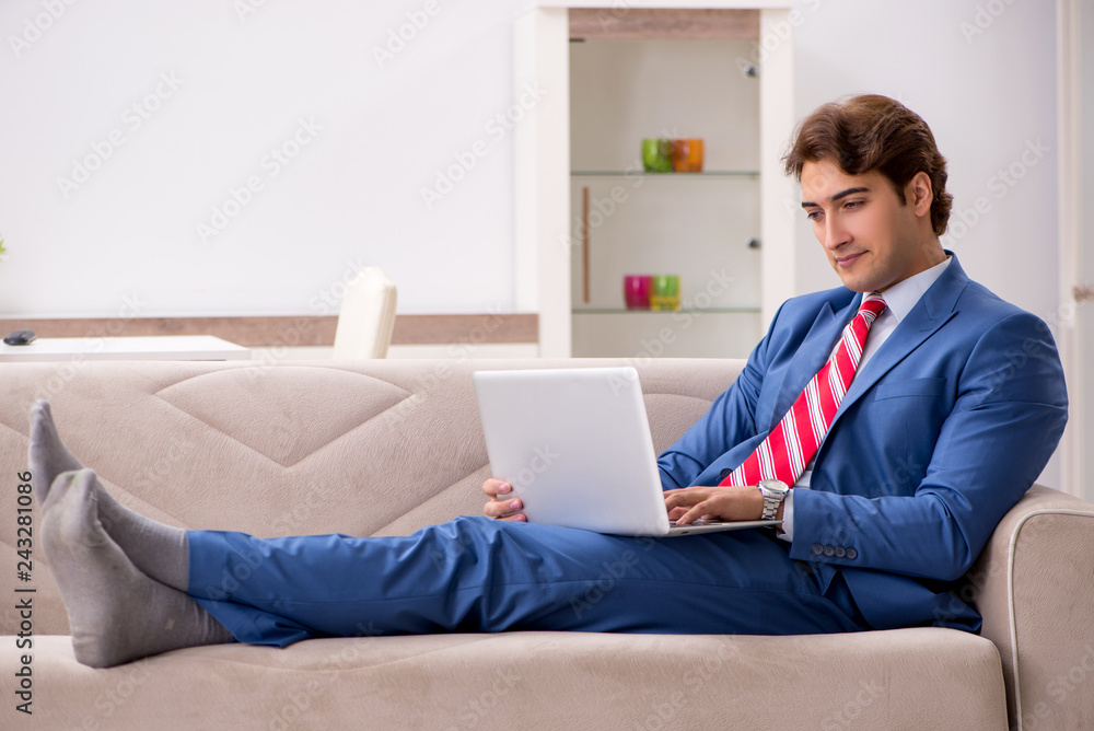 Young businessman working at home sitting on the sofa Young businessman working at home sitting on the sofa