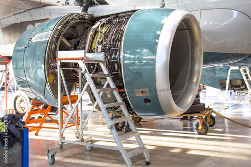 Maintenance, opened aircraft engine in the hangar in huge industrial hall