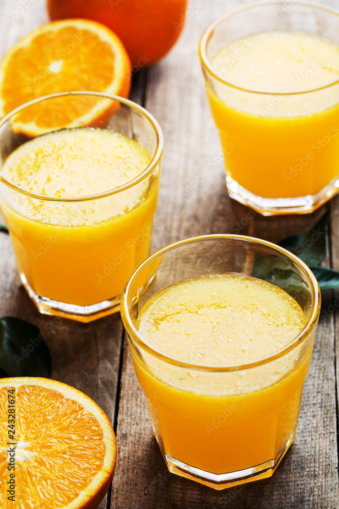 Freshly pressed orange juice, surrounded by fresh oranges Freshly pressed orange juice, surrounded by fresh oranges