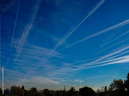 Airplane chemtrails in blue sky