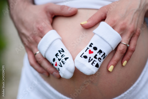 Healthy pregnancy concept. Pregnant Woman holding her hands in a heart shape on her baby bump. Pregnant Belly with fingers Heart symbol. Maternity concept. Baby Shower © fotofrol
