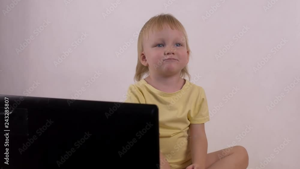 Little caucasian girl plays and plays with computer laptop, emotions, 4K Little caucasian girl plays and plays with computer laptop, emotions, 4K