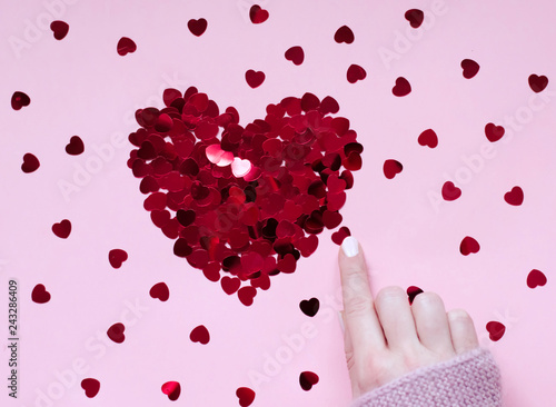 Heart of sequins on a pink background. 14 February