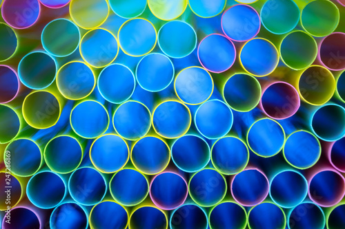 Drinking straw bundle from behind with colored illuminated, blue