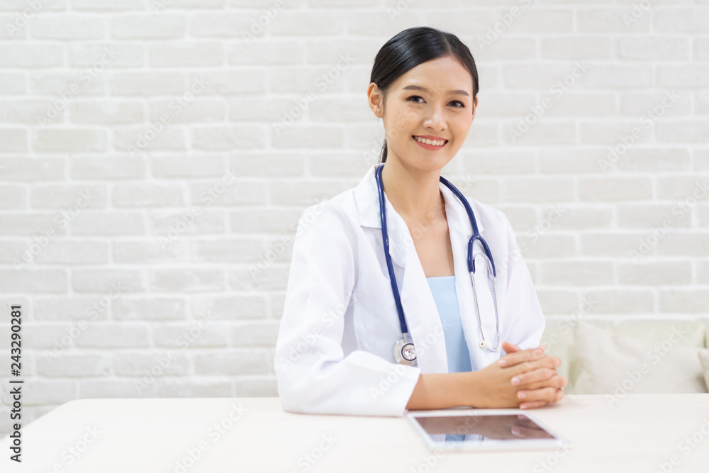 Closeup portrait of smiling beautiful female asian doctor standing with her arms crossed. Medicine representative concept on brick background. Closeup portrait of smiling beautiful female asian doctor standing with her arms crossed. Medicine representative concept on brick background.