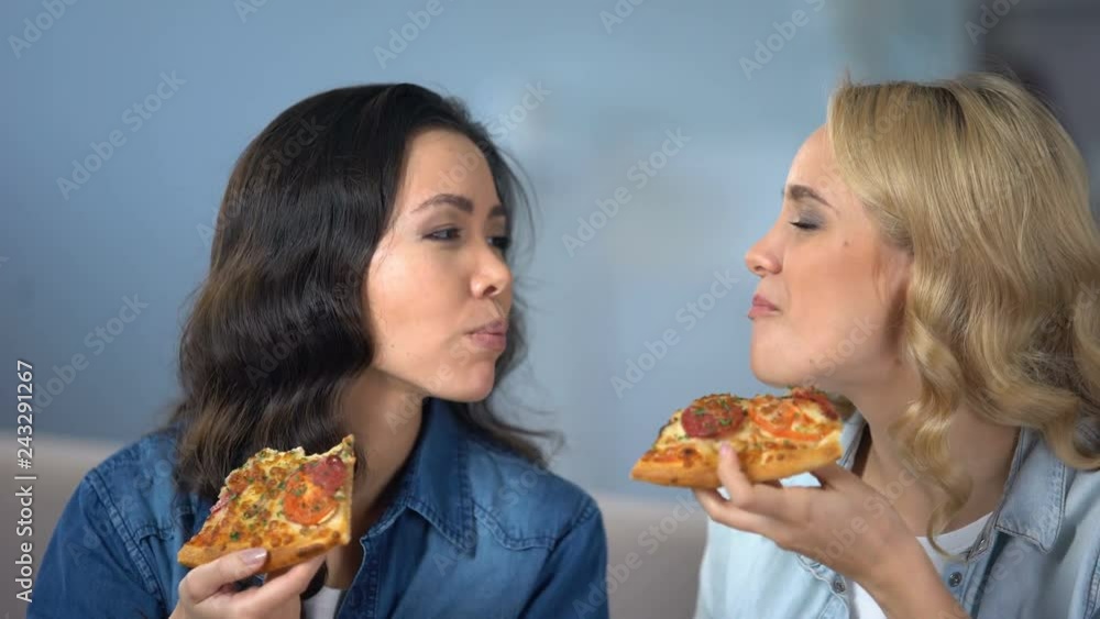 Hungry female friends enjoying delicious pizza, italian cuisine, food delivery