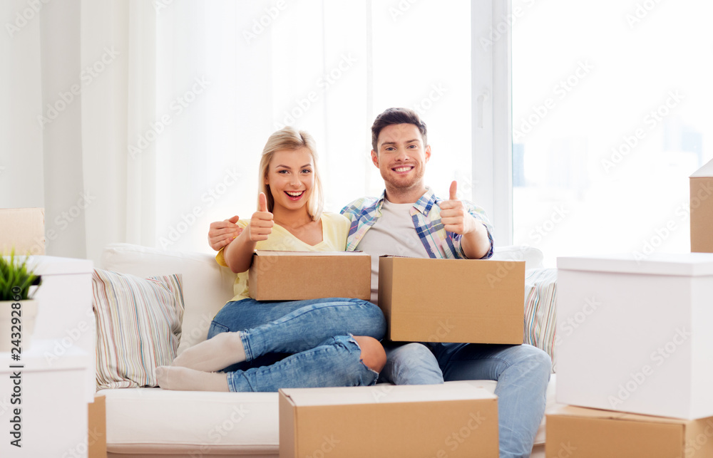 mortgage, moving and real estate concept - happy couple with boxes resting on sofa at new home mortgage, moving and real estate concept - happy couple with boxes resting on sofa at new home