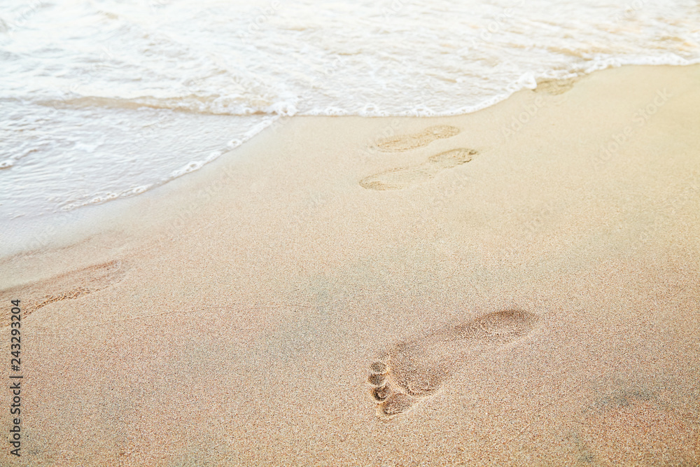 Foot prints on the beach of a seashore near the sea Foot prints on the beach of a seashore near the sea