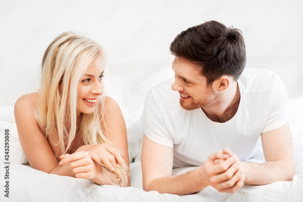 love, relationships and people concept - happy couple lying in bed at home love, relationships and people concept - happy couple lying in bed at home