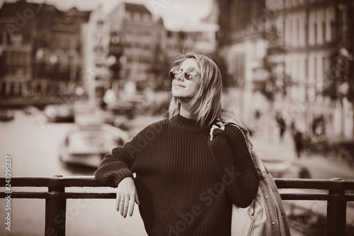 Photography Young girl in sweater and orange sunglasses at bridge in Amsterdam street