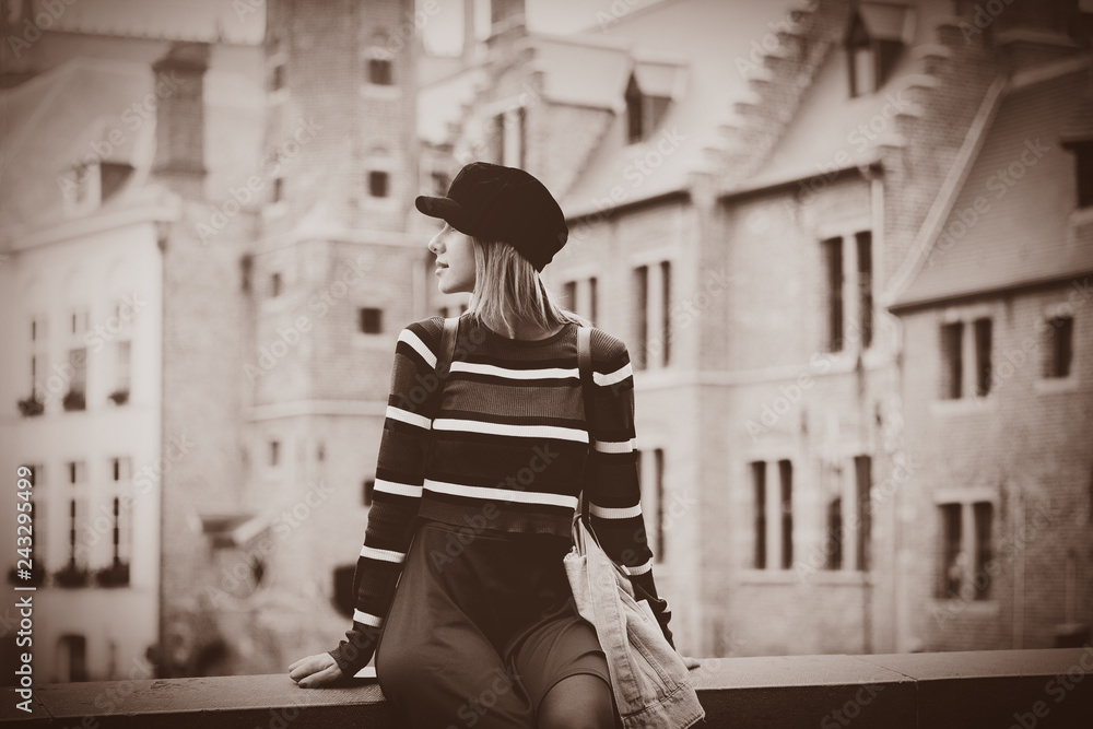 Young girl red sweater, in hat at streets of Bruges, Belgium. Autumn season Image in sepia color style