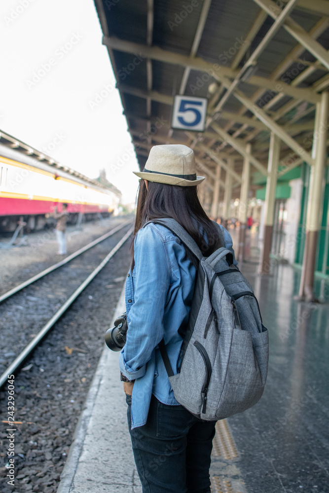 young asian tourist girl hold camera to travel at railway station
