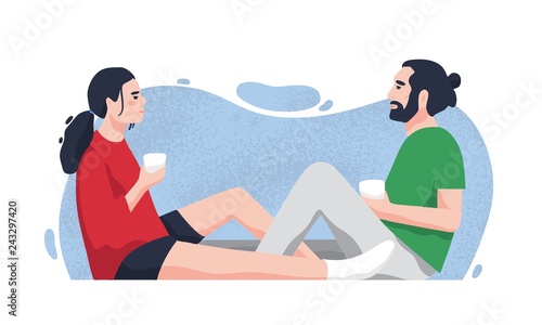 Romantic partners sitting on floor and drinking tea or coffee