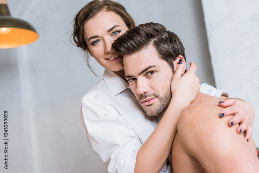 Fototapeta premium adult couple embracing and looking at camera